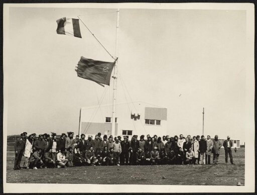 24ème mission : Cérémonie du 11 novembre 1974, photo de groupe devant des drapeaux