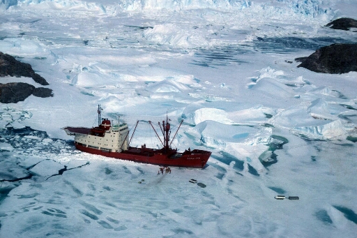Survol du Thala Dan au mouillage dans l'archipel. Déchargement en cours. Le chaos de glace de l'Astrolabe en arrière plan.