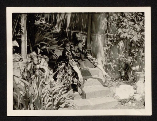 Marie Corbel assise sur des marches dans le jardin de la maison de Caluire - mission CNRS 1963