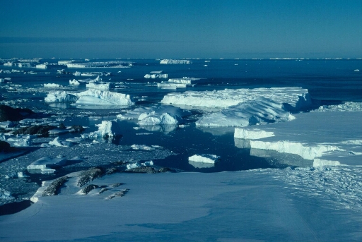 Vue aérienne vers le nord. Au premier plan le nunatak puis l'île Lamarck. Les icebergs détachés de l'Astrolabe (à droite) et le large, mer libre.