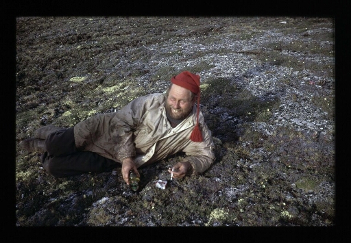Moment de détente à la base Corbel. Un homme par terre fumant une cigarette - mission CNRS 1965