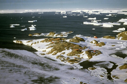 Survol, vers le nord-est, des îles des Pétrels et voisinnes. Mer libre, nombeux icebergs. Le Thala Dan accosté à la banquise.