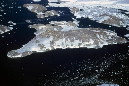 Vue aérienne vers le sud-est : les îles des Pétrels, C.Bernard, Buffon, Lamarck et J.Rostand. Le flan ouest de l'Astrolabe. Pack près du glacier,mer libre au-delà.