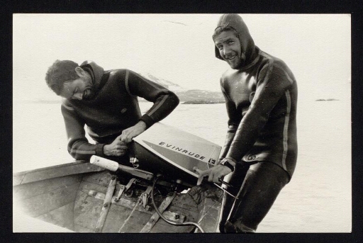 Deux hommes en tenue de plongée bouteille s'affairent près d'un moteur de bateau - - mission CNRS 1965