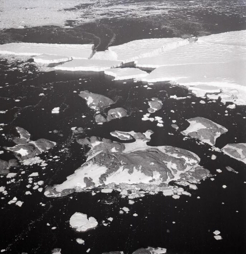 Survol à très haute altitude de l'archipel et du glacier de l'Astrolabe et de plusieurs icebergs qui s'en détachent.