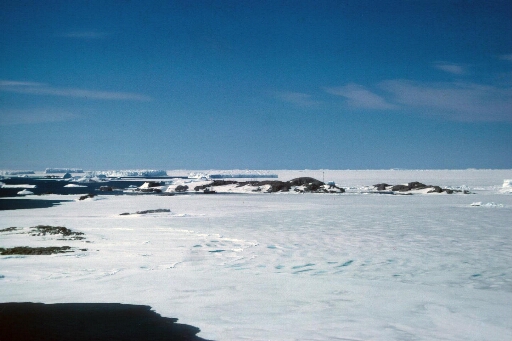 Vue aérienne à basse altitude prise au niveau de l'île du Gouverneur (à gauche) en direction de l'archipel. Mer libre à gauche et banquise vers le nord-est.