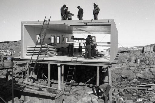 Construction du bâtiment télécommunications (n°46). Huit hommes pour la pose des panneaux Spair.
