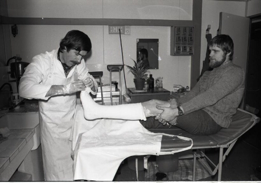 Pendant l'hivernage, le médecin Bruno Pats confectionne un plâtre sur la jambe de son patient.