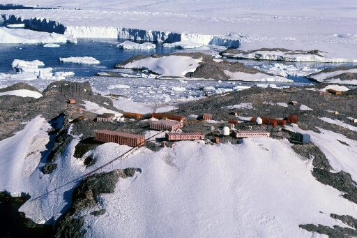 Vue aérienne du centre de la base en direction de l'île Jean Rostand, du Nunatack du Bon Docteur, du glacier de l'Astrolabe et du continent.
