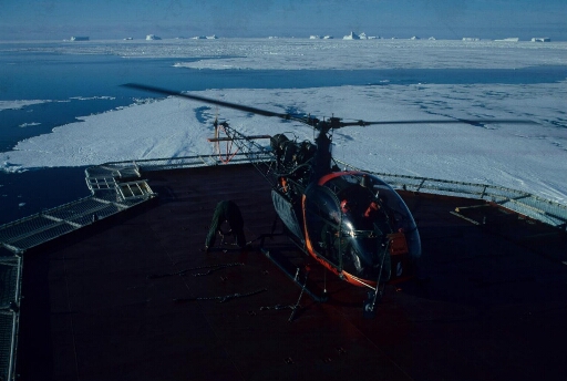 L'hélicoptère tout juste posé sur le pont duThala Dan. Alternance de mer libre et de banquise à perte de vue. Icebergs à l'horizon.
