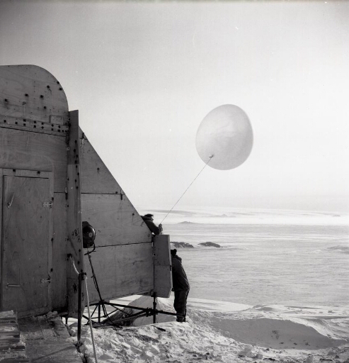 Depuis l'abri météo, le ballon-sonde météo prêt à partir par beau temps calme. Au loin le continent.