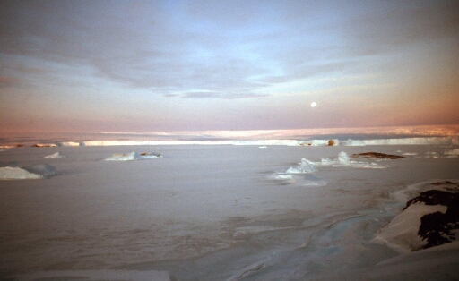 Lune et soleil d'hiver sur le continent Antarctique avec le Glacier de l'Astrolabe en front de banquise.