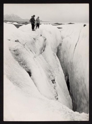 Deux personnes devant un trou de glace profond