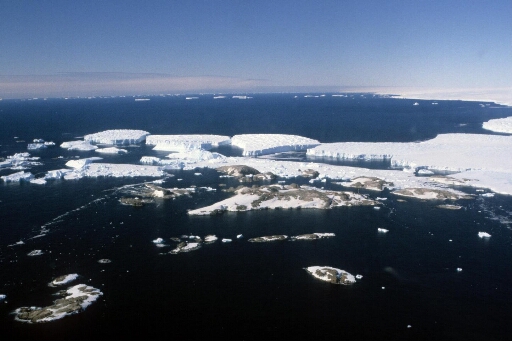 Survol, vers le sud-est, de l'archipel en direction des icebergs issus du glacier de l'Astrolabe puis le continent. Mer libre.
