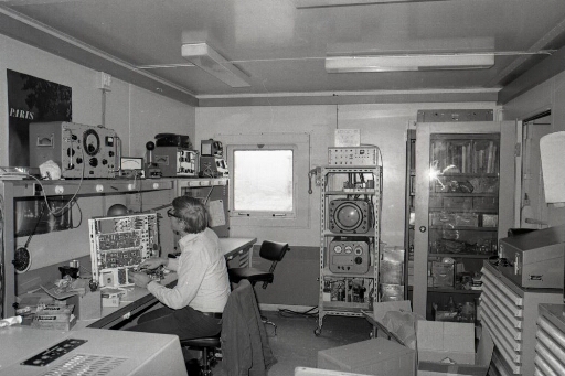 Le technicien radio Christian Bazin contrôle un récepteur radio dans son atelier du bâtiment radio (n°46).