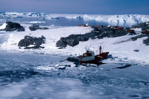 Vue aérienne vers le nord-est : le Thala Dan amarré à la côte ouest de l'île des Pétrels. Au loin les icebergs de l'Astrolabe.