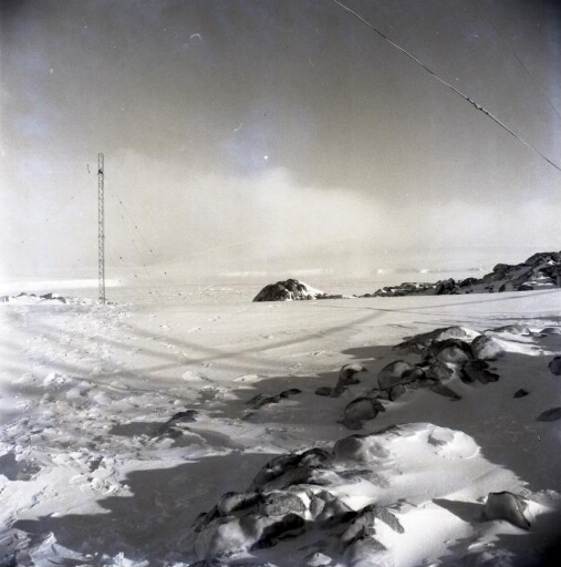 La station sous la neige. Le pylône de la radio. Au loin, le continent.