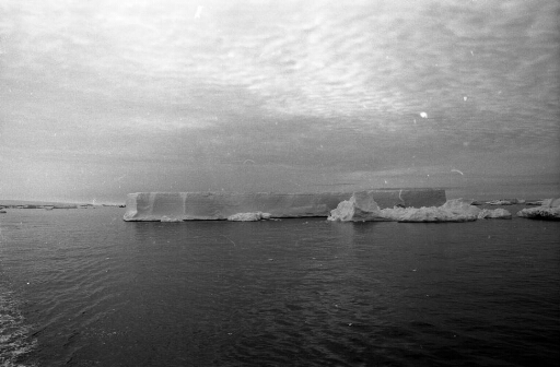 Iceberg tabulaire non loin du continent et de l'archipel de Pointe Géologie.