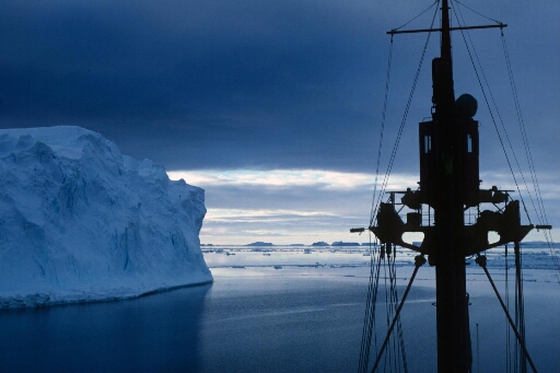 Vue depuis la passerelle du Thala Dan naviguant en mer libre près d'un gros iceberg tabulaire. Icebergs à l'horizon.