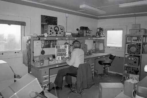 Dans l'atelier du bâtiment radio (n°46), le technicien Christian Bazin répare un équipement radio.