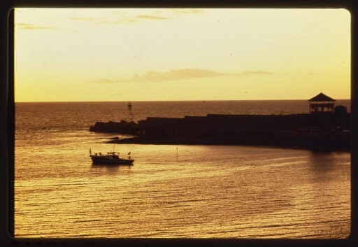Vue sur une barque et le quai de débarquement au levé ou coucher du soleil. Série de Diapos. N° 4