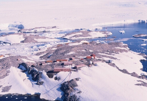 Vue aérienne du centre de la base en direction des îles Jean Rostand et Le Mauguen (ex A. Carrel) et du Nunatack du Bon Docteur et du continent.