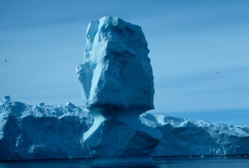 Petit iceberg de forme remarquable proche de grands icebergs tabulaires.