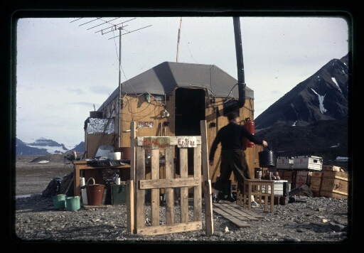 Un homme s'affairent autour d'une cabane - mission CNRS 1964