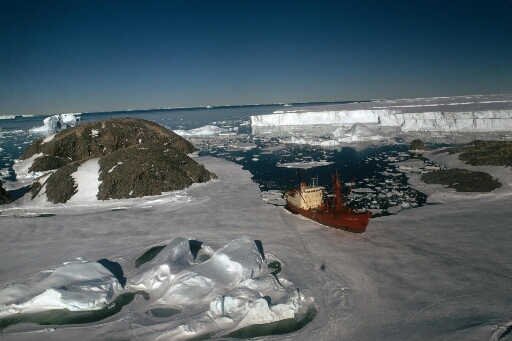 Survol, vers le nord-est, du Thala Dan accosté à la banquise près des îles Bufon, Claude Bernard et Lamarck. Le glacier de l'Astrolabe.