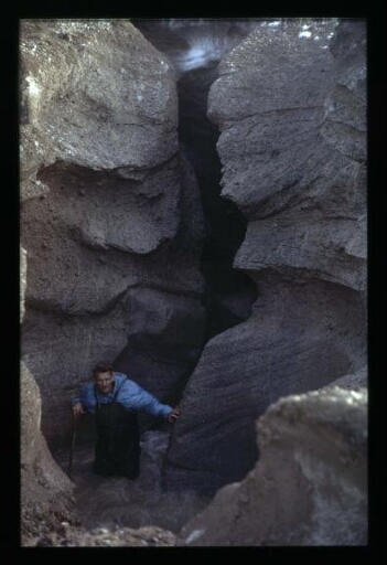 Jean Corbel debout dans le fond d'une rivière entre deux falaises - mission CNRS 1966