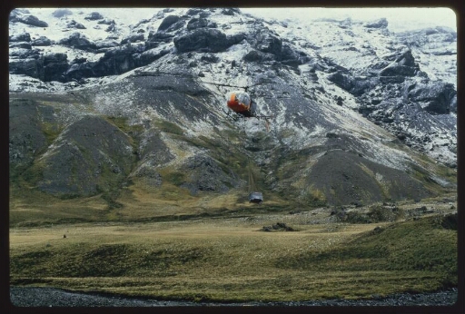 Hélicoptère hélitreuillant une charge. Montagne en arrière-plan. Diapo 2