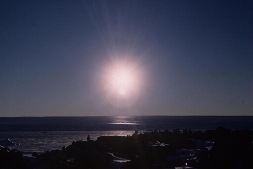 Parélie observée quand le soleil est bas sur l'horizon. Au premier plan, l'une des colonies manchots Adélie sur l'île des Pétrels.