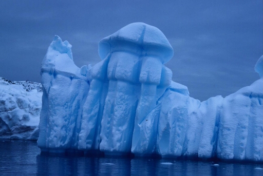 Petit iceberg de forme remarquable. En arrière-plan l'une des îles de l'archipel non identifiée.