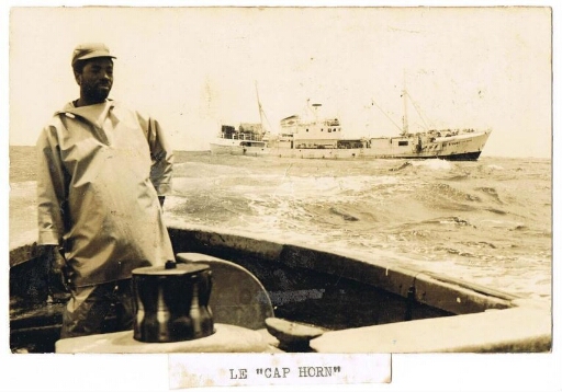 Marin posant devant le navire "Cap-Horn"