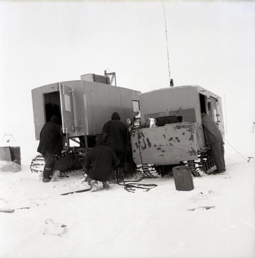 Quatre hommes s'emploient pour la remise en service de l'un des deux véhicules.