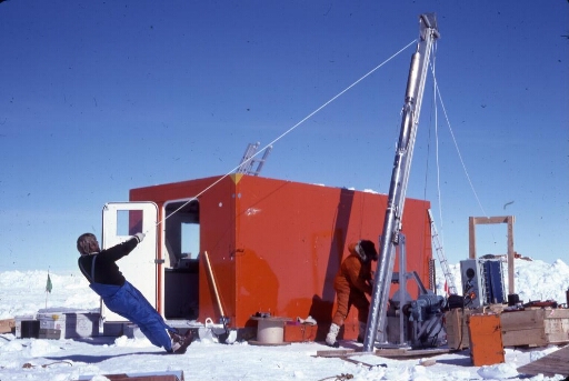 A Dôme C, le chantier de forage glaciologique : deux glaciologues procédent à l'installation du carottier.