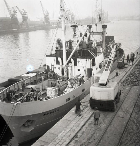 Le Norsel à quai, derniers préparatifs avant l'appareillage. Dockers et marins sur le pont.