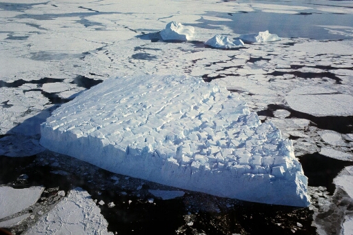 Survol d'un iceberg tabulaire dans un pack assez dense.