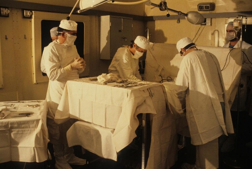 Intervention chirurgicale : au cours de la campagne d'été, dans la salle opération de l'infirmerie, médecin(s) et assistants autour de leur patient.