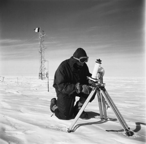 Le glaciologue Claude Lorius effectue des mesures du rayonnements reçu et émis par la neige.