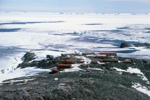 Vue aérienne vers le nord, du centre de la base. La pointe nord de l'île Cuvier. Banquise en partie disloquée, nombreux icebergs à l'horizon.