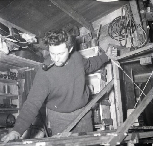 Dans l'atelier, le photographe Roger Kirschner répare un traîneau.