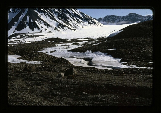 Vue sur le sol rocailleux, la neige et des montagnes enneigées - mission CNRS 1966 - vue 1