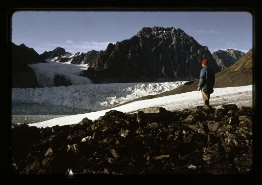 Un homme debout devant le glacier de la Baie du Roi- mission CNRS 1965
