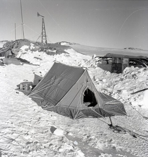 Une tente dressée pendant la construction de la baraque. Au second plan, l'éolienne et les antennes. Beau temps.
