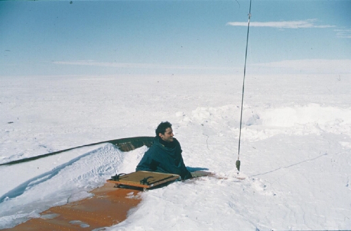 Le glaciologue Claude Lorius sort par la trappe supérieure d'un sno-cat enseveli sous la neige. Le retour vers Dumont d'Urville est proche.