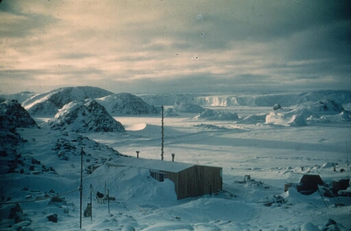 La base Marret en hiver après une neige récente. A l'arrière-plan, le mont Rose sur l'île des Pétrels, l'île Lamarck et le glacier de l'Astrolabe.