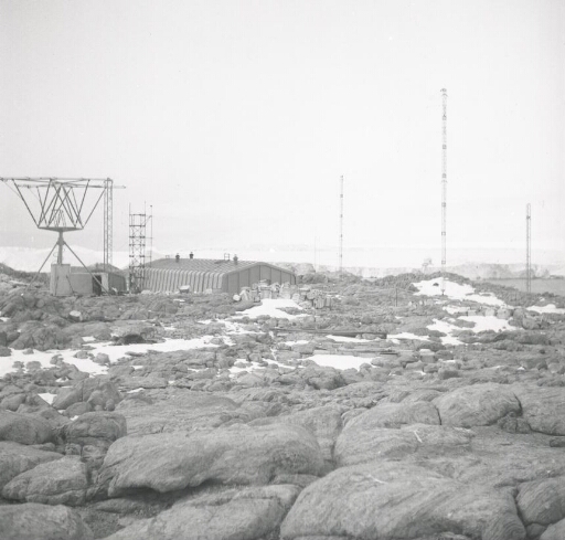 Vue générale de la station : sondeur ionosphérique, mâts météo et radio, bâtiments principal et atelier.