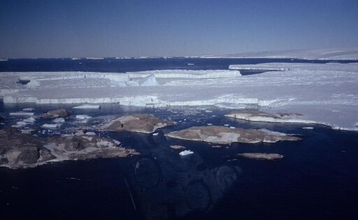 Vue aérienne vers le sud-est : le sud de l'île des Pétrels, les îles Jean Rostand et Le Mauguen, le nunatak puis le glacier de l'Astrolabe et le continent.