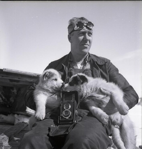 Portrait en buste du mécanicien centrale René Dova avec deux chiots futurs chiens de traîneau.
